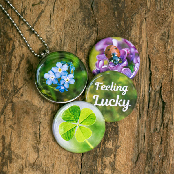 Roestvrij stalen fotomedaillon ketting met vier verschillende verwisselbare voorkanten. Met close up foto`s van geluksbrengers,luchy charms, klavertje vier,lieveheersbeestje en vergeet-me-nietjes. Rvs/roesvrij stalen fotomedaillon. Voor het dicht bij je dragen van je speciale foto.