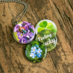 Roestvrij stalen fotomedaillon ketting met vier verschillende verwisselbare voorkanten. Met close up foto`s van geluksbrengers,luchy charms, klavertje vier,lieveheersbeestje en vergeet-me-nietjes. Rvs/roesvrij stalen fotomedaillon. Voor het dicht bij je dragen van je speciale foto.