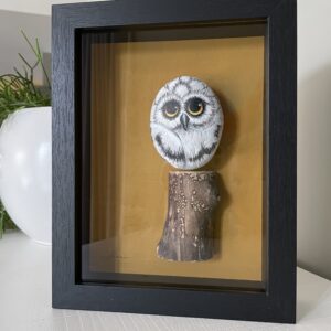 Handbeschilderde uil op grote pebblestone zittend op een stuk drijfhout, ingelijst kunstwerk.