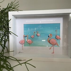 Kunstwerk met flamingo’s van handbeschilderde keitjes in een serene baai, omlijst in een dieptelijst.
