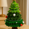 Handgemaakte groene kerstboom met houten voet en pareldecoratie