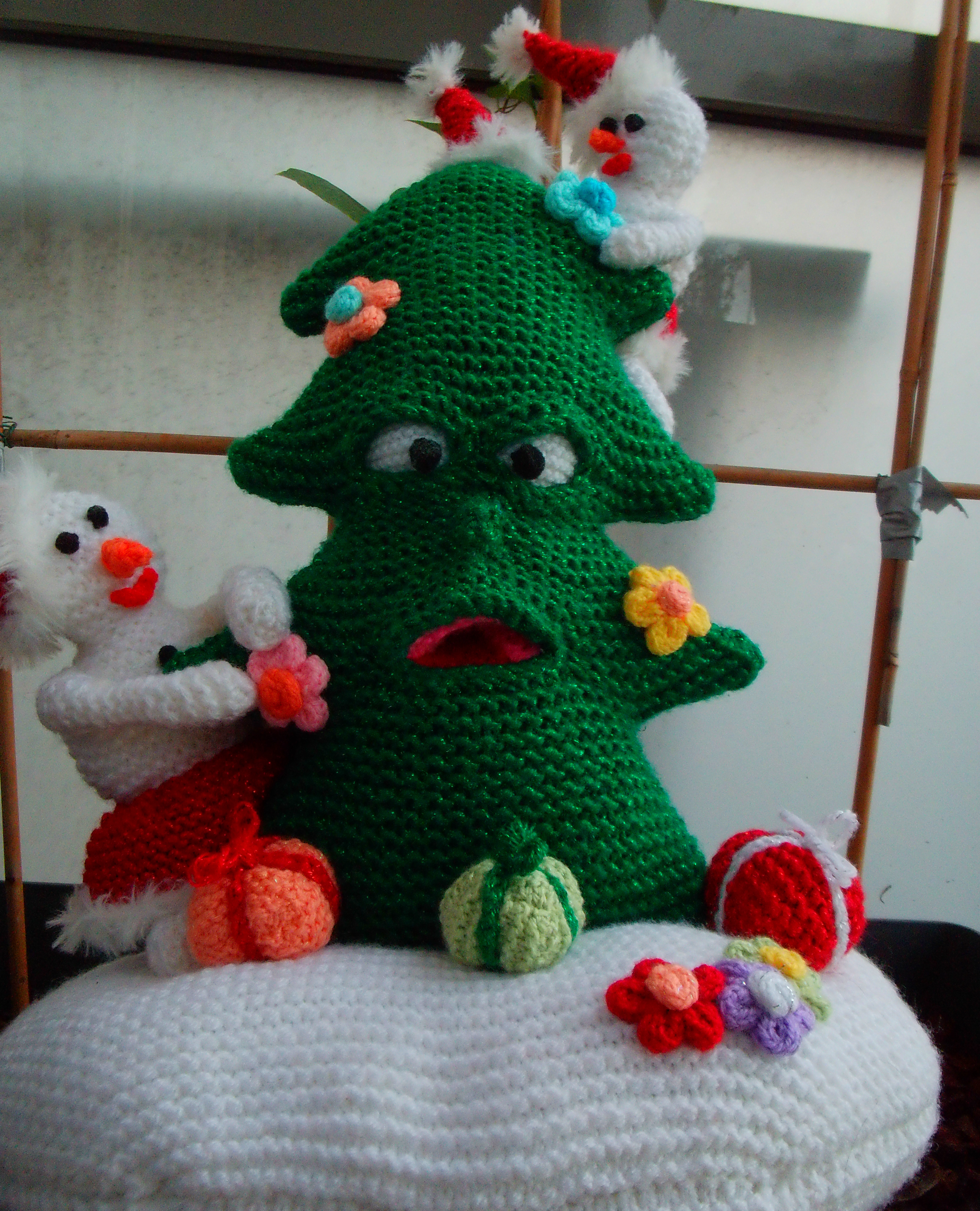 Verbaasde glitter kerstboom met kleine sneeuwpoppen.