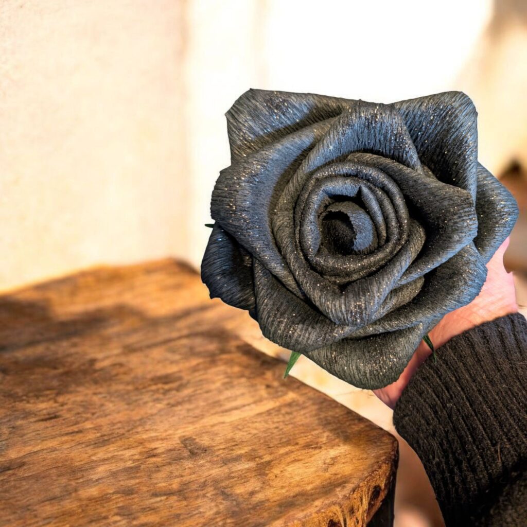 Elegante, handgemaakte zwarte papieren roos met subtiele glitters, zorgvuldig vormgegeven voor luxe decoratie, cadeau-momenten of stijlvolle interieuraccenten.