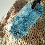glazen hanger met blauwe bubbels met zwarten ketting