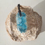 glazen hanger met blauwe bubbels met zwarten ketting