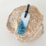 versmolten glazen hanger met zeegezicht en zwarte ketting