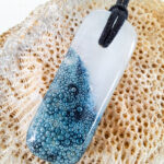 versmolten glazen hanger met zeegezicht en zwarte ketting