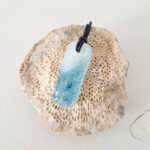 Gesmolten glazen hanger met aqua blauw zeegezicht, kustlijn. Met zwarte ketting