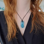 glazen hanger met blauwe bubbels met zwarte ketting